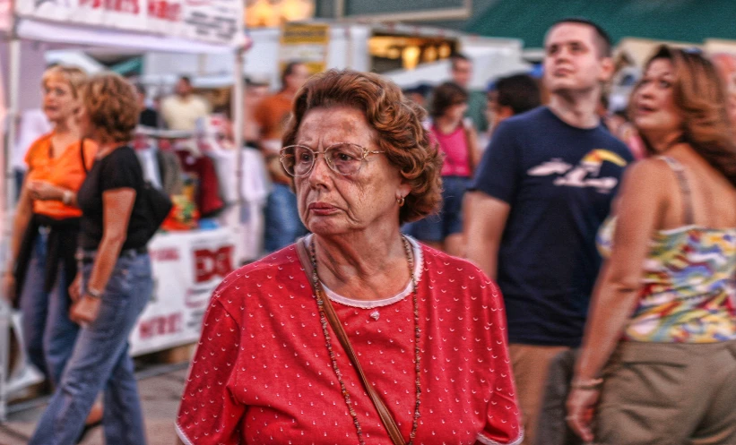 an elderly woman walking down a busy street