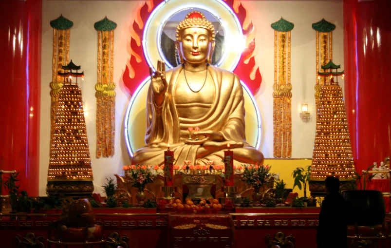 the golden buddha statue sits in front of a stage