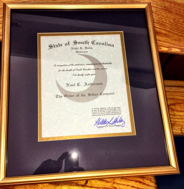 a framed certificate sitting inside a wooden frame