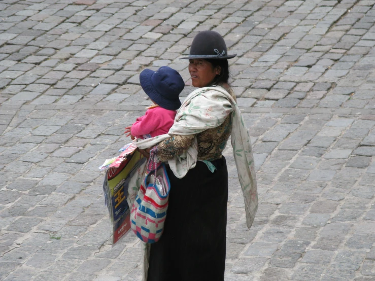 a woman carries a child across the street