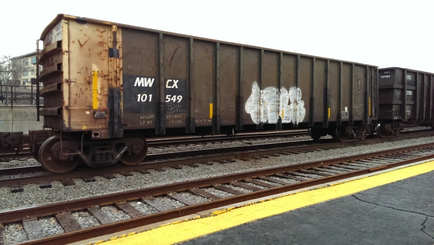 a train car sitting on top of a track with graffiti