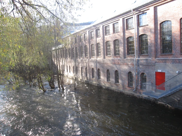 a building along side a river with water flowing under