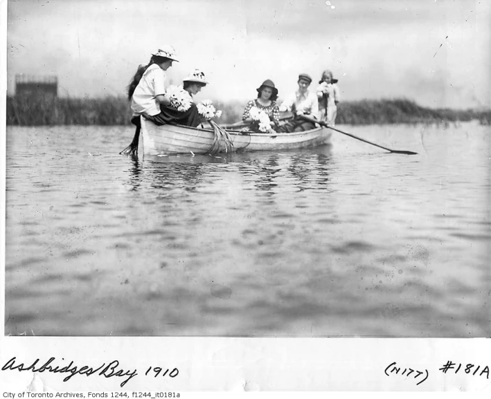 old black and white pograph of four people in a small boat