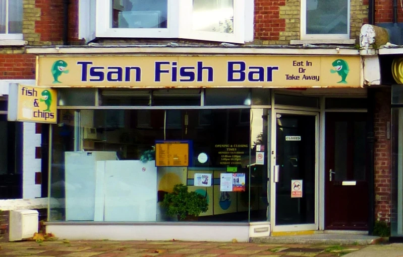 a fish bar in a brick building next to the street