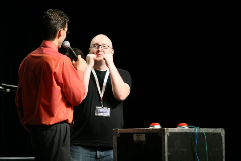 a man in a black shirt is talking on a mic