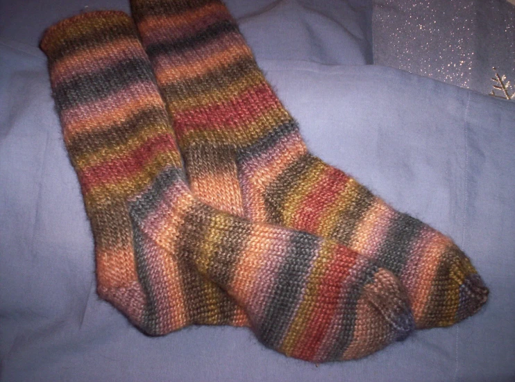 a pair of colorful socks sitting on top of blue fabric