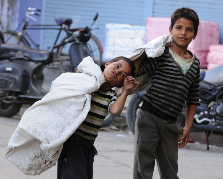 two boys with clothes hanging on their backs