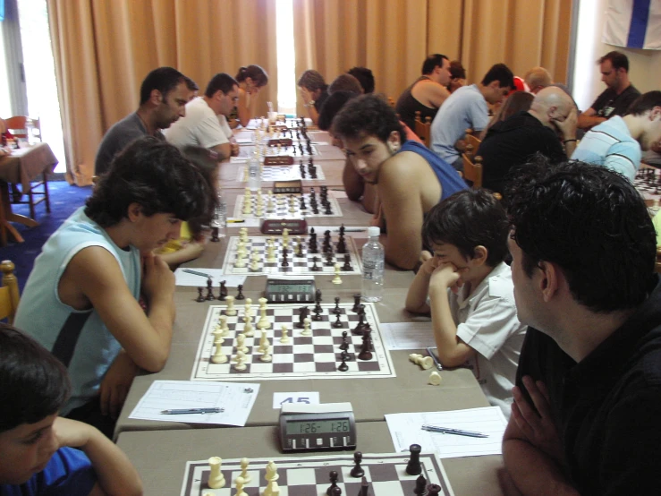 people are sitting at a table playing chess