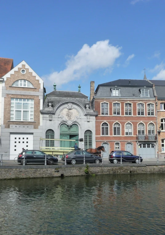 a row of buildings beside water and car