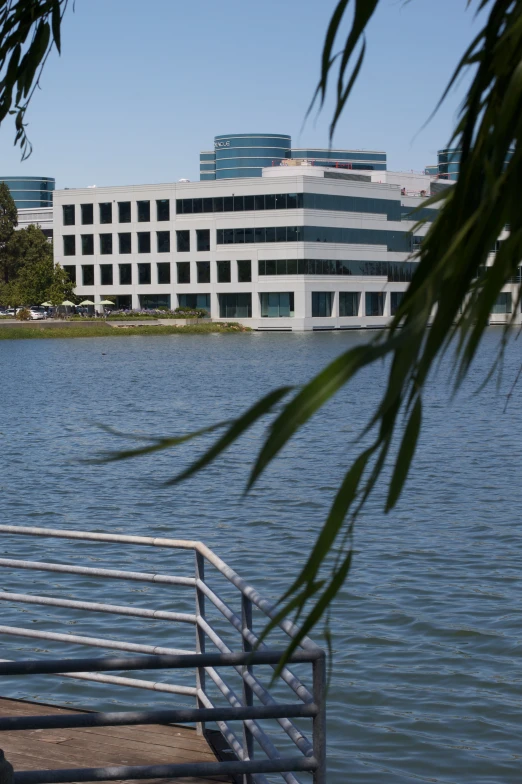 a large building over water next to a metal railing