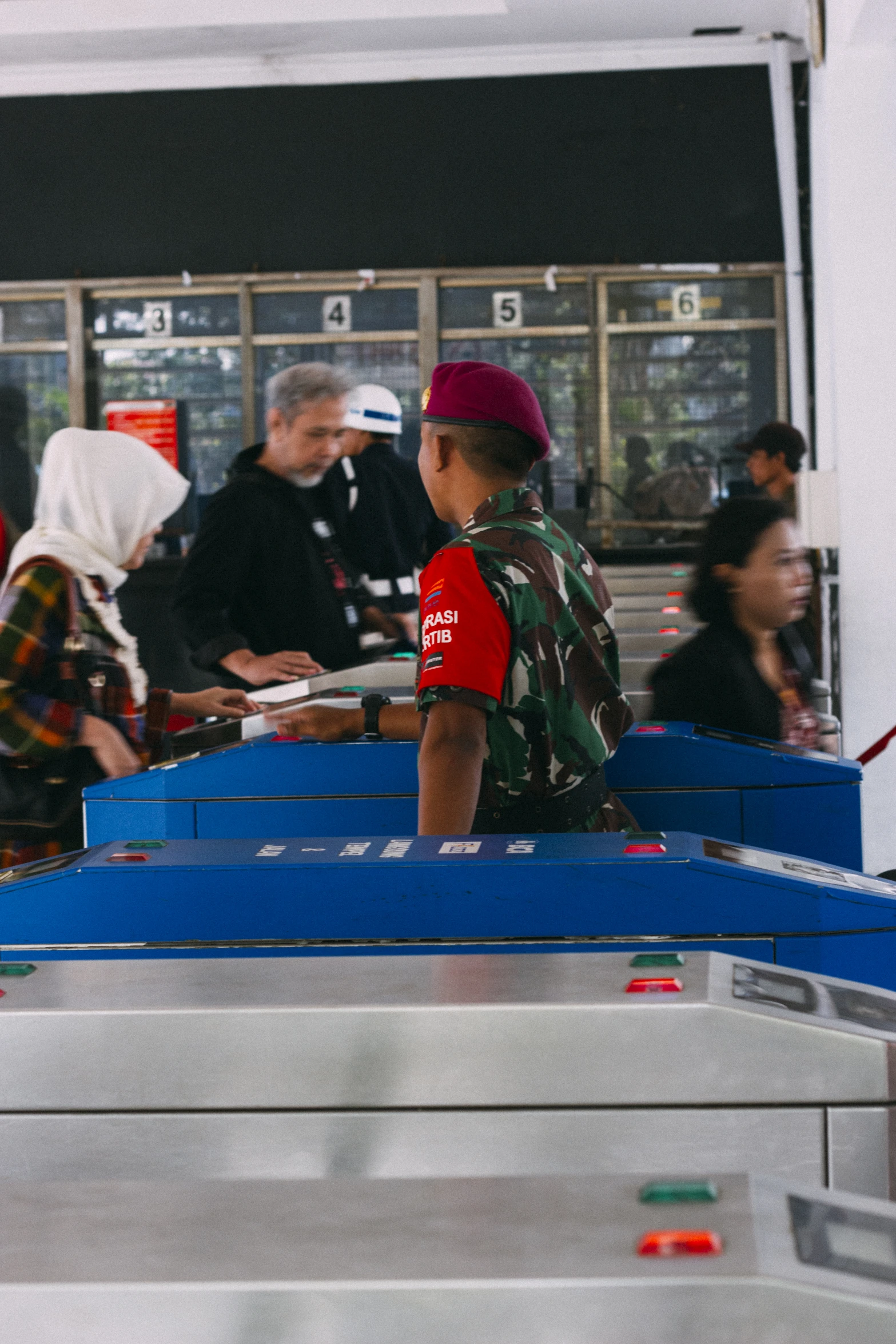 a boy wearing a red hat in a terminal waiting for passengers