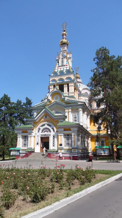 a large building with an ornate tower that is painted yellow and white