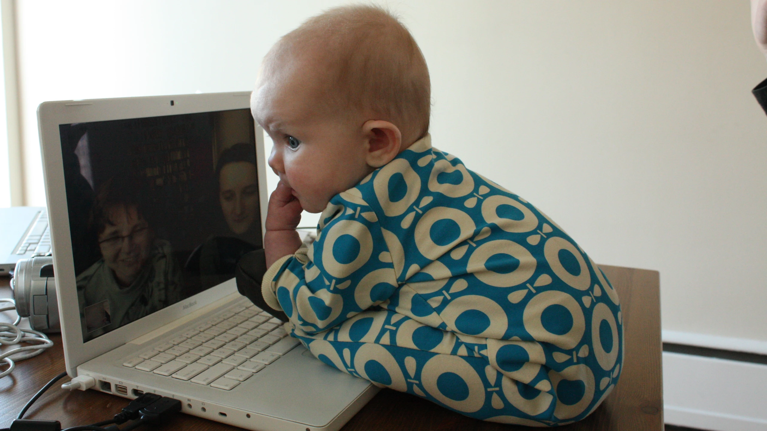 a baby sitting on top of a laptop computer