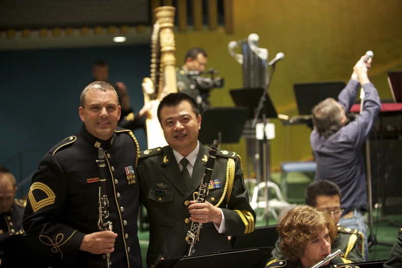 two men in military uniforms are posing with musicians