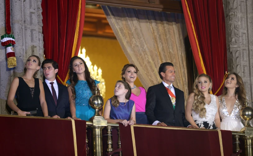 a man and woman in suit and ties standing next to children