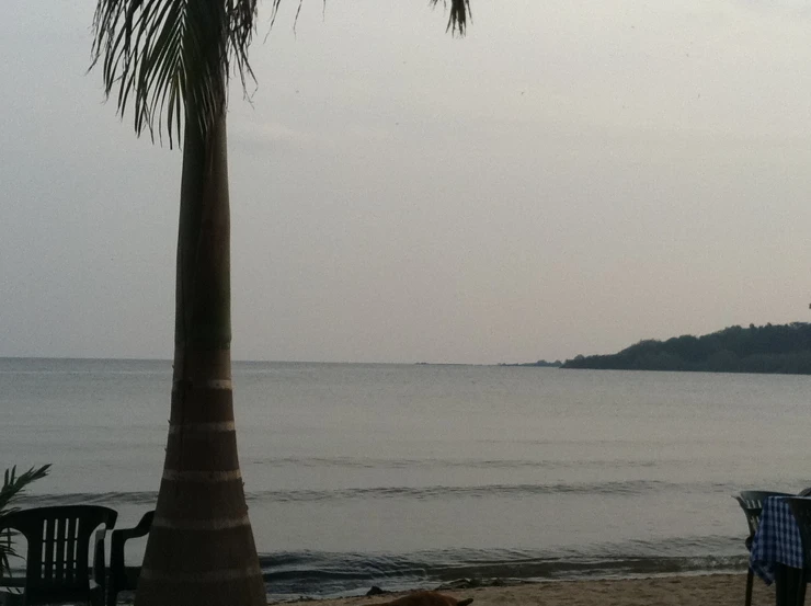 some chairs on the beach next to water