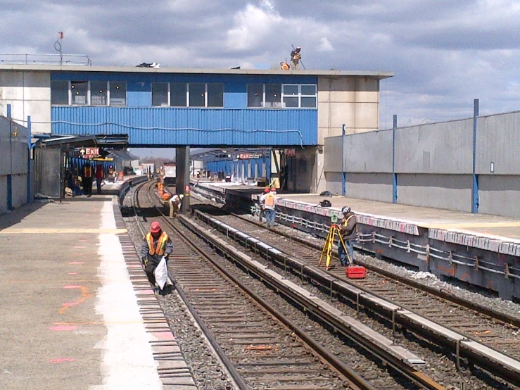 some people with safety jackets are standing at a train station