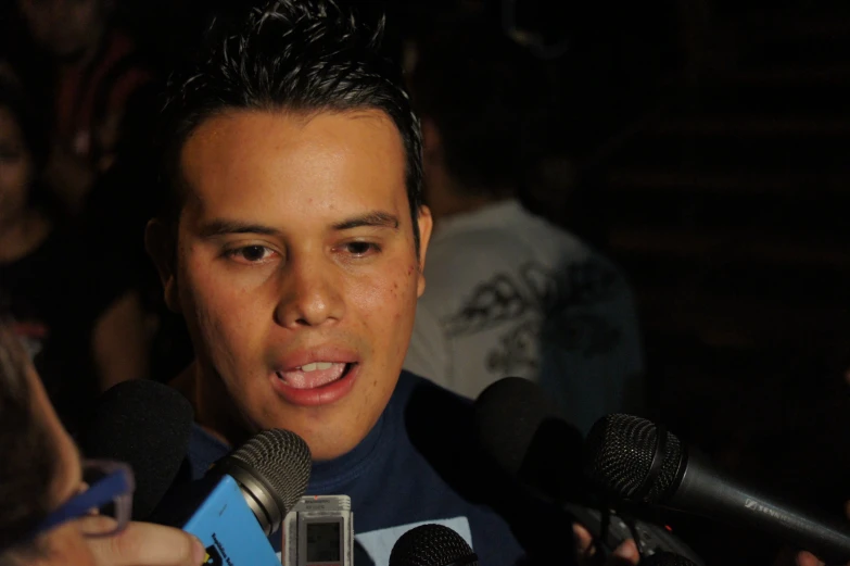 a young man is interviewed while holding a microphone