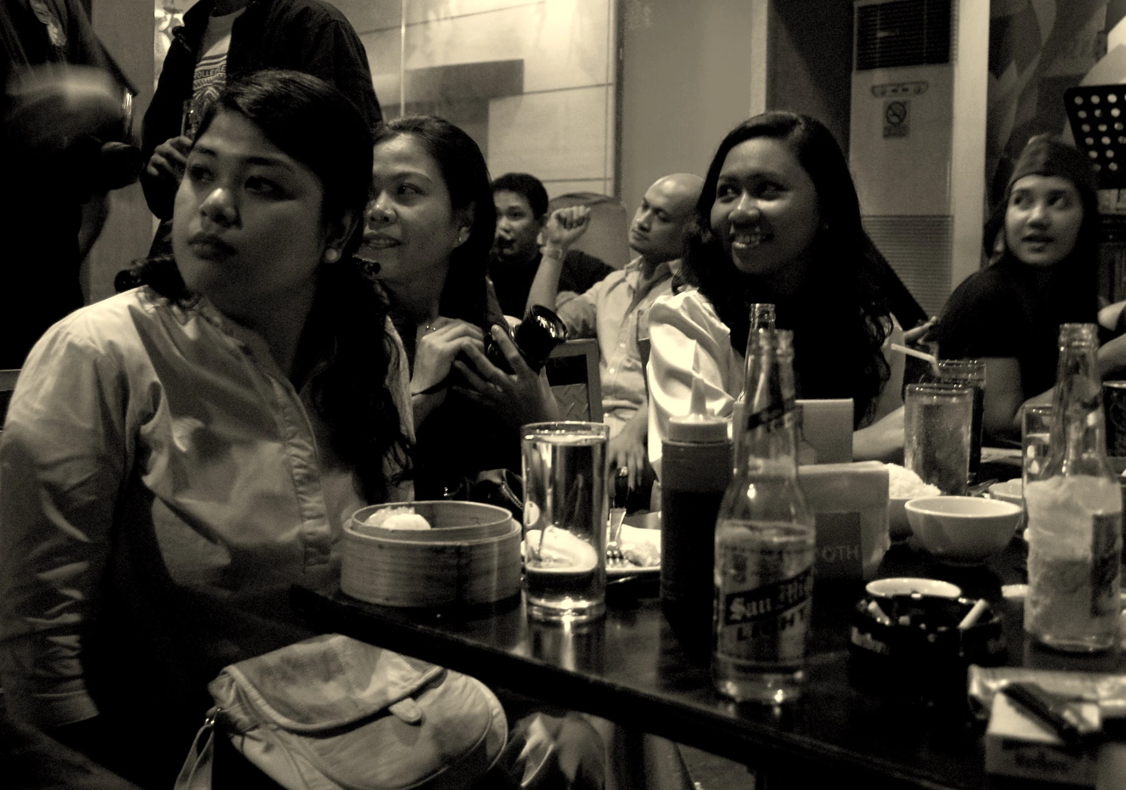 black and white image of people sitting down for a meal