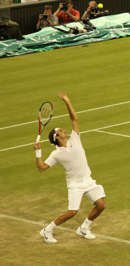 a tennis player is reaching up to hit the ball