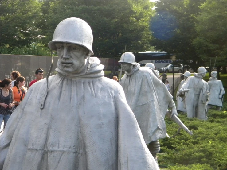 some statues in the grass are posed for a po