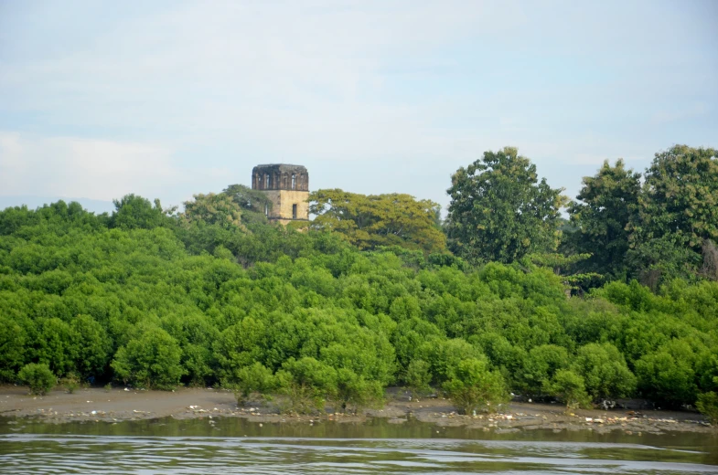 an old castle on top of a hill next to some water