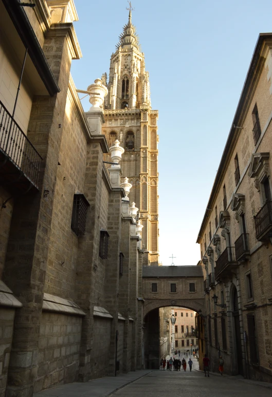 the arched stone alley with some building in the background