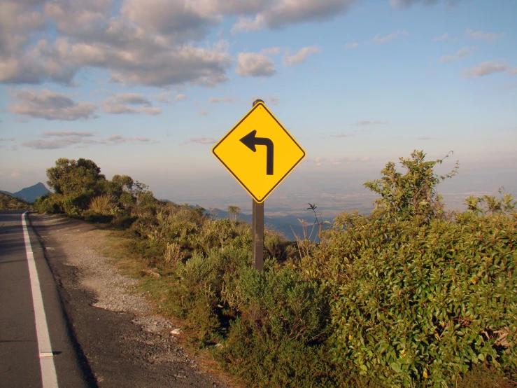 an arrow is on a sign that is indicating that you can turn left