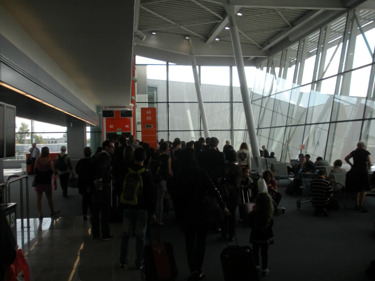 passengers standing in line by an airport lobby