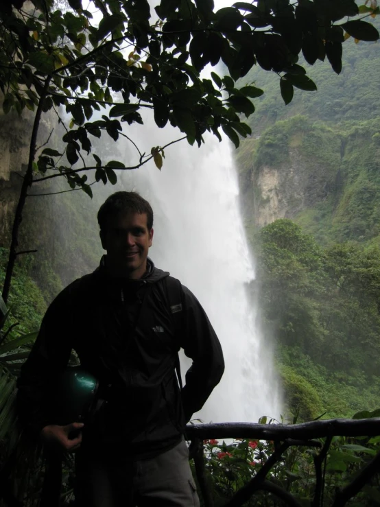 a person standing on a balcony near a waterfall