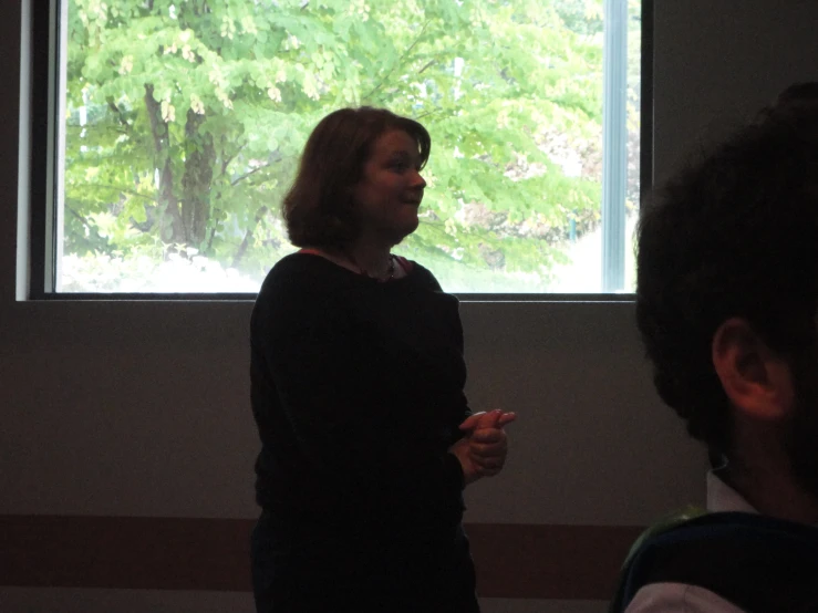 woman standing by a window in a darkened room