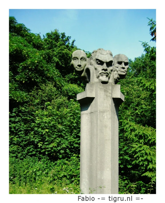 a group of heads of men that are on the side of a monument