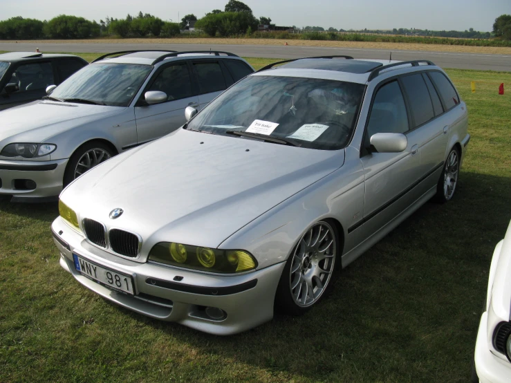 the three cars are parked on the grass