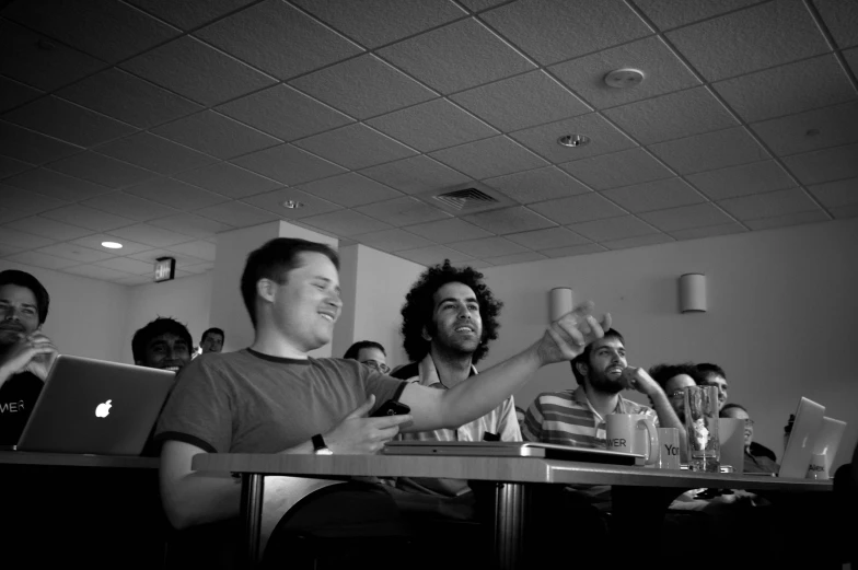 a group of people sitting in front of laptops