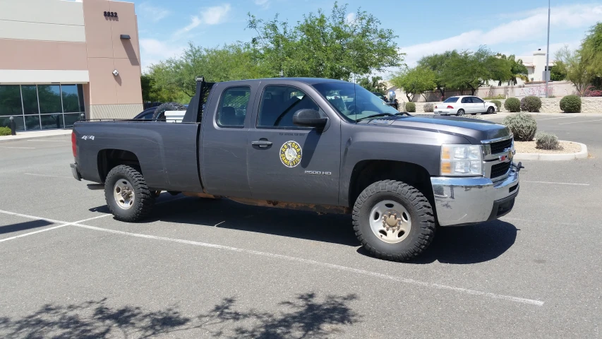 the gray truck is parked on the side of the road