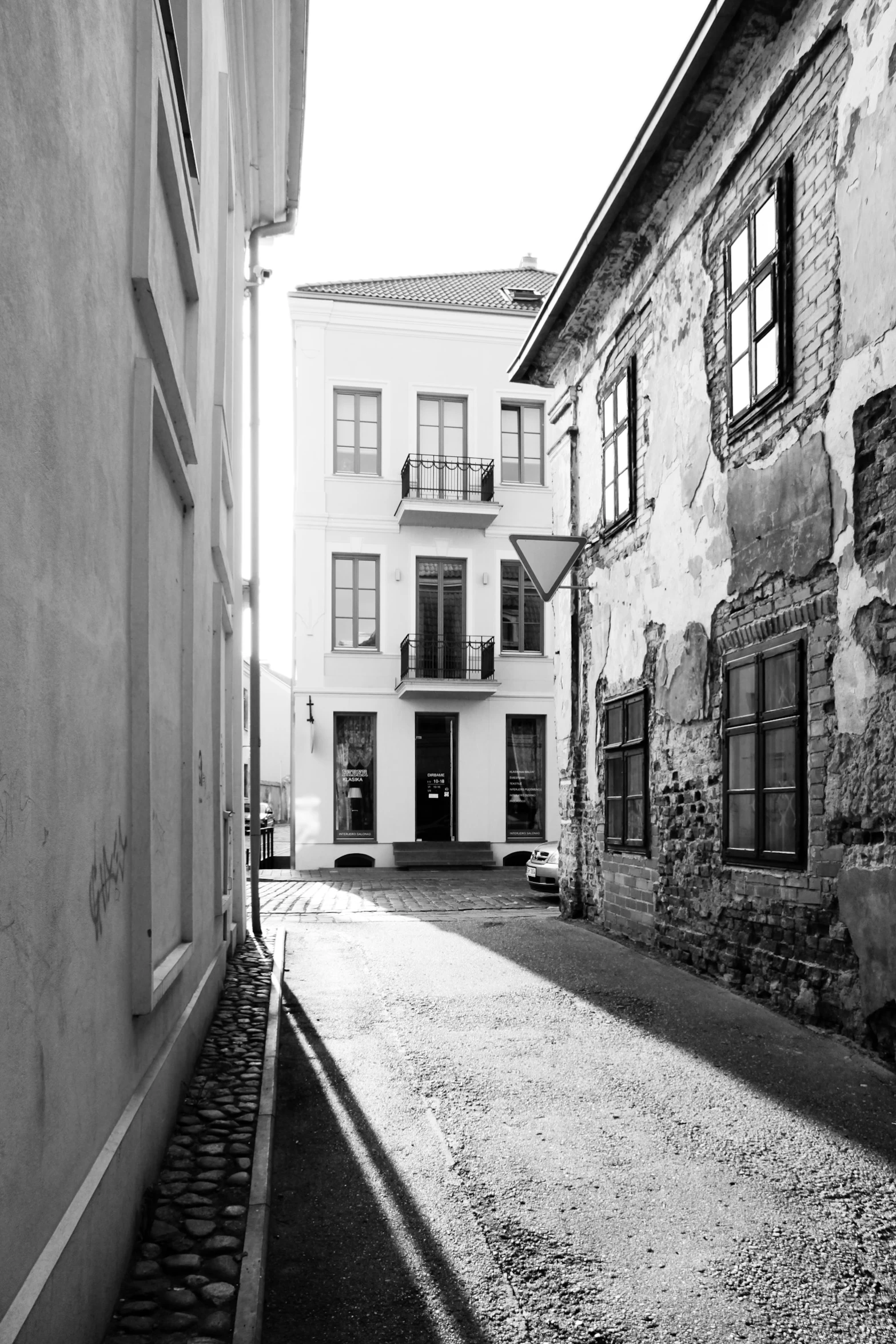 a quiet alley way surrounded by white buildings