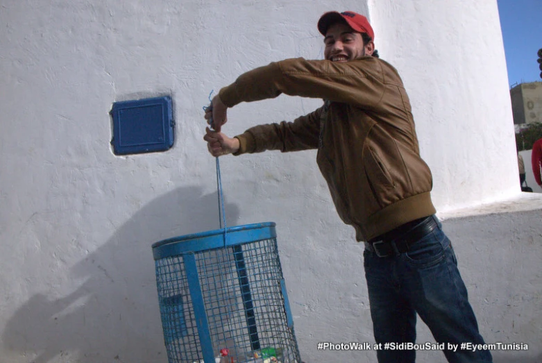 a man is holding soing to his face as he leans on the wall