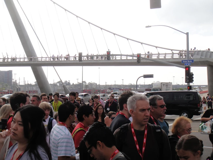 a large crowd of people is waiting on the bridge