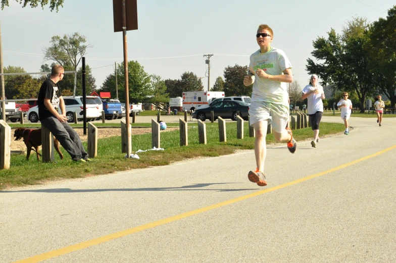 young men running on the side of a road