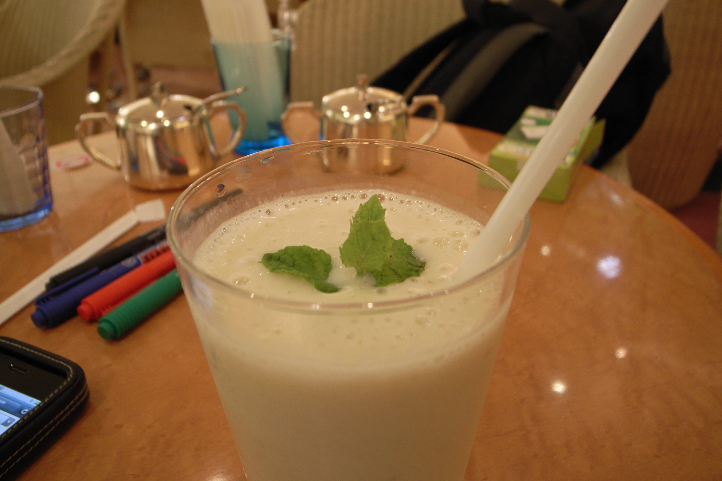 a glass full of liquid and green leaf on top