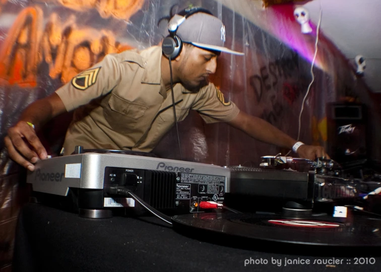 a man in uniform operating an electronic music mixer