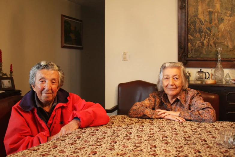 two people pose for the camera while sitting at a table