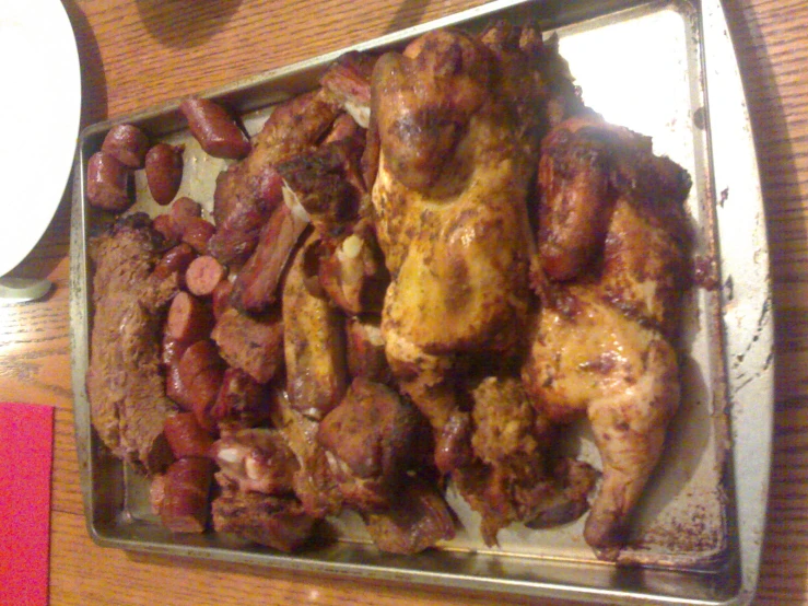 a tray filled with meat and beans sitting on a table