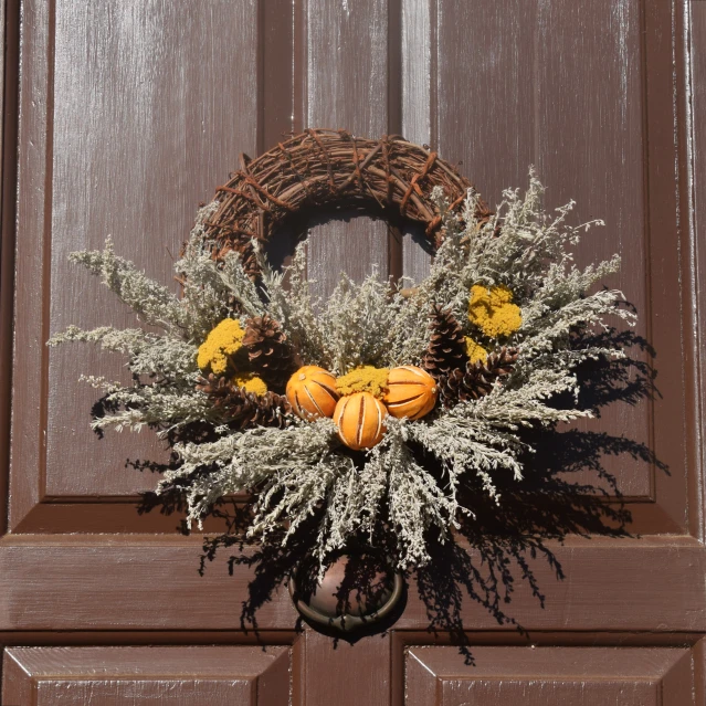 the wreath is hung on the door handle with pumpkins