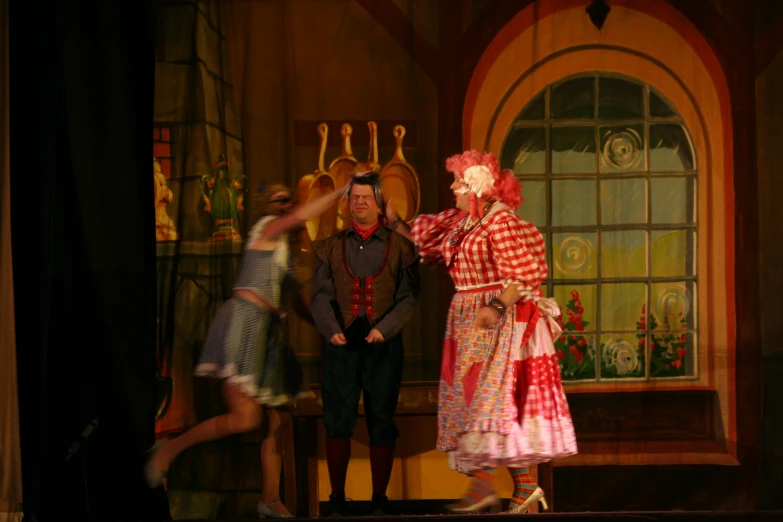 three people dressed in period costumes on stage