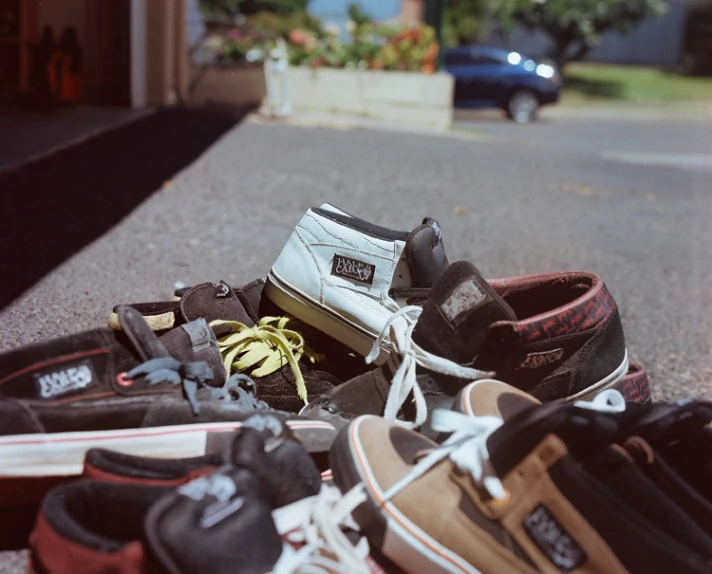 group of men's sneakers and skateboards resting on the road