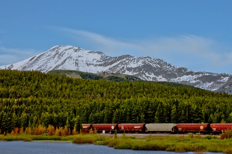 a train in the mountains next to a river