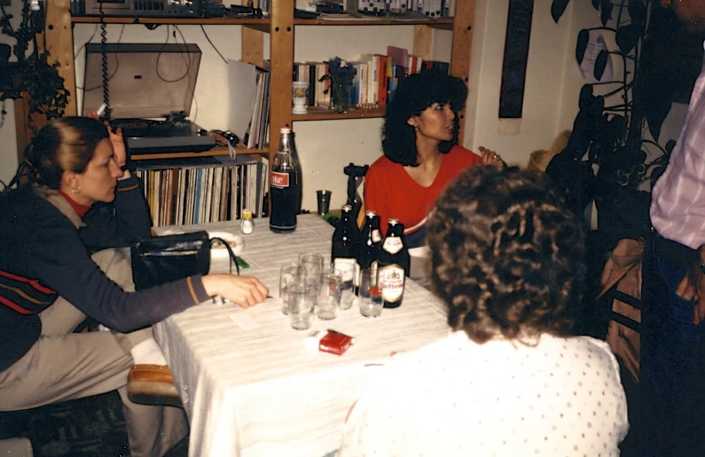 some women sitting at a table and some bottles