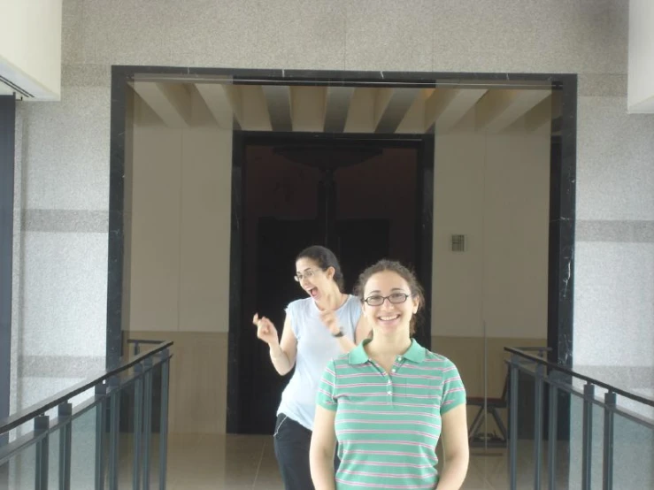 two women are standing outside of an entrance