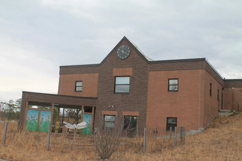 a brick building with a clock and broken windows